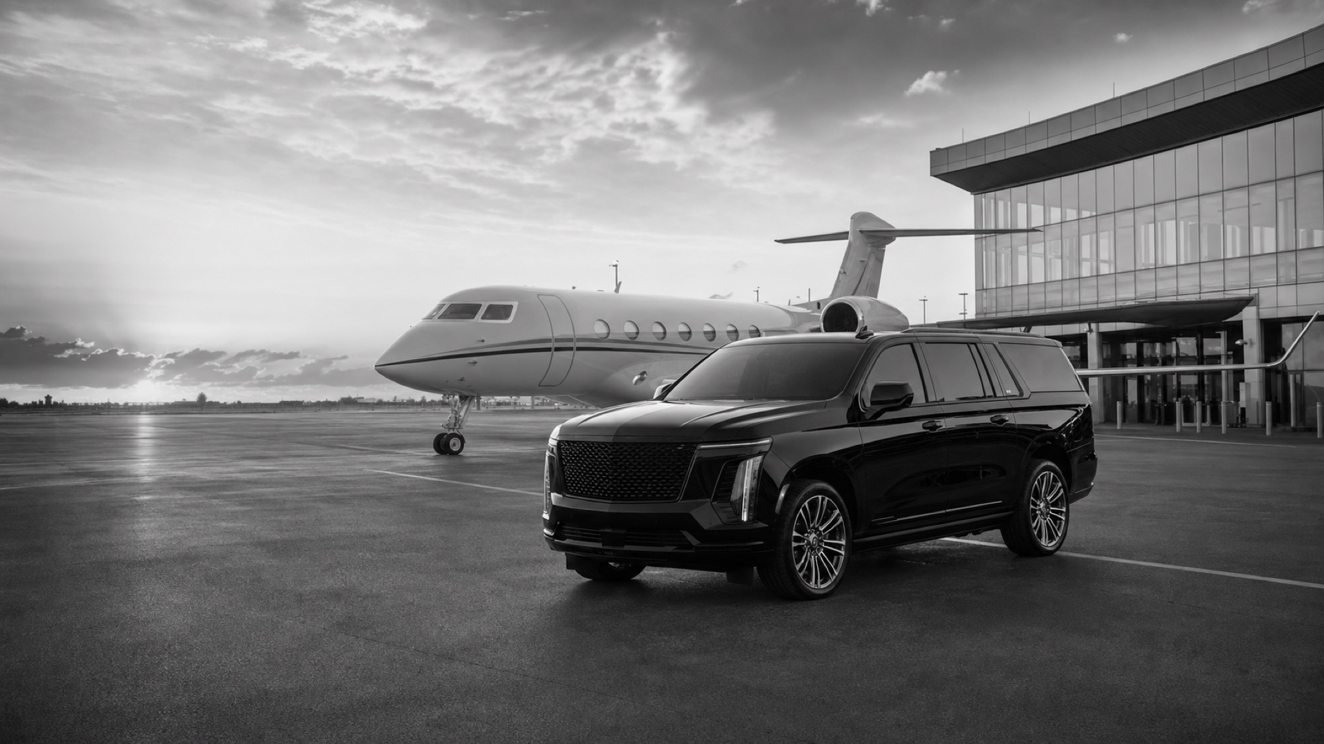 Black luxury SUV beside a private jet at an executive aviation terminal