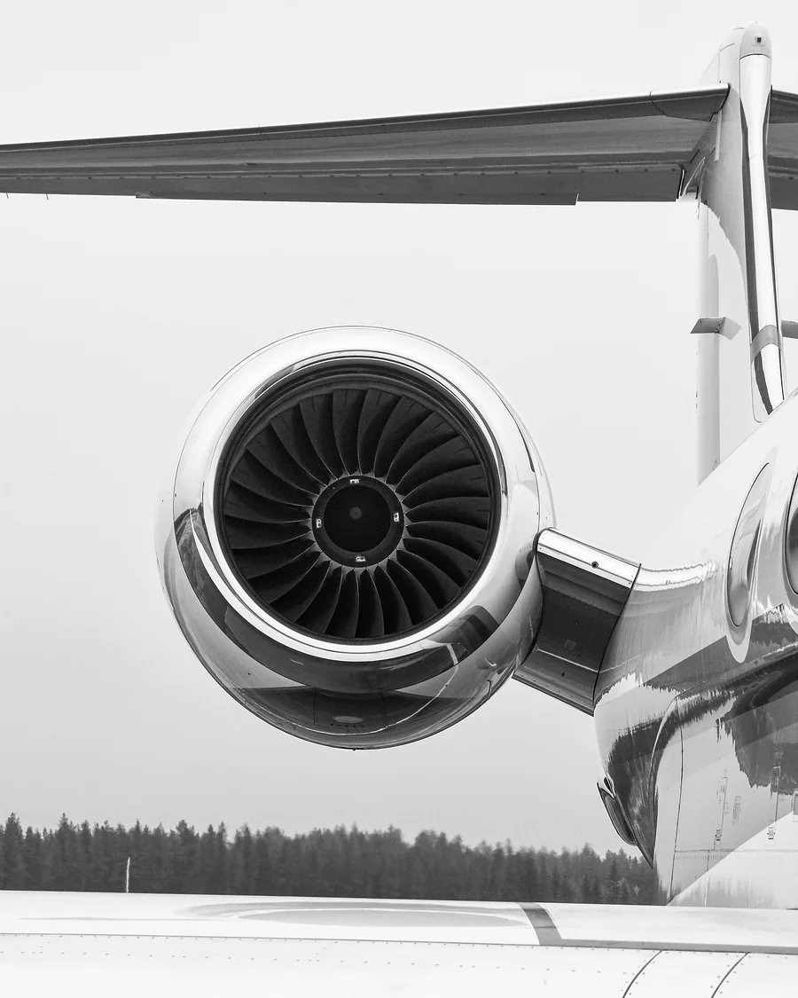 Professional chauffeur beside a black 2026 Mercedes-Benz S 500 and private jet